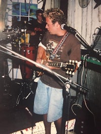 a man playing guitar in front of a microphone